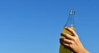 オレンジジュースを持つ子供の手