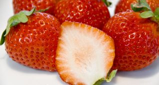 お皿に乗ったたくさんの苺とカットされた苺