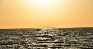 海に浮かぶ船とオレンジ色の空