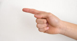 指を指す男の子の手