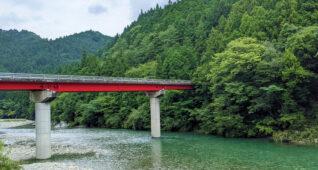 穏やかな川に架かる赤色の橋